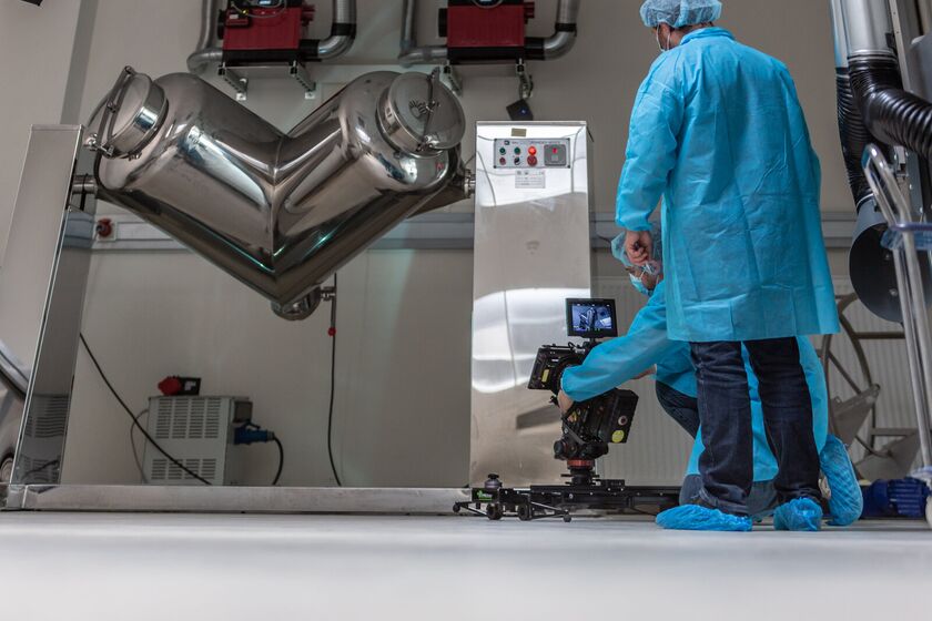 Cinematography am Set beim Lactopia Pharma Imagefilm in Saarbrücken, Detailaufnahme der Pharmaproduktionslinie unter blau akzentuiertem Licht
